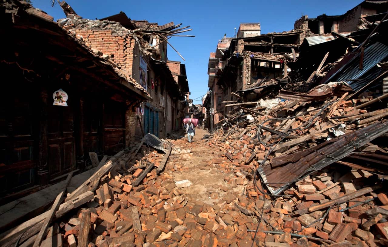 A photo of a Nepalese man walking through destruction caused by the April 2015 earthquake