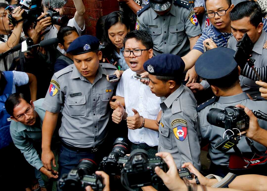 Reuters journalist Wa Lone is surrounded by police and reporters outside a court in Yangon after being handed a seven year jail term. 