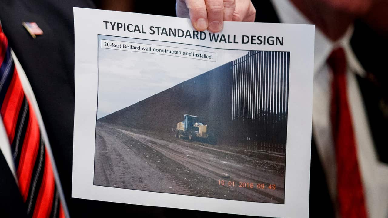 US President Donald Trump presents a 'typical standard wall design' as he participates in a roundtable discussion on border security on 11/1/19.