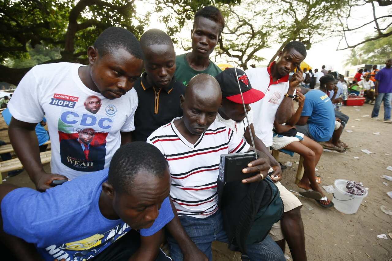 Supporters of the Coalition for Democratic Change (CDC), listen to provisional results on the radio at party headquarters in Monrovia (AAP)