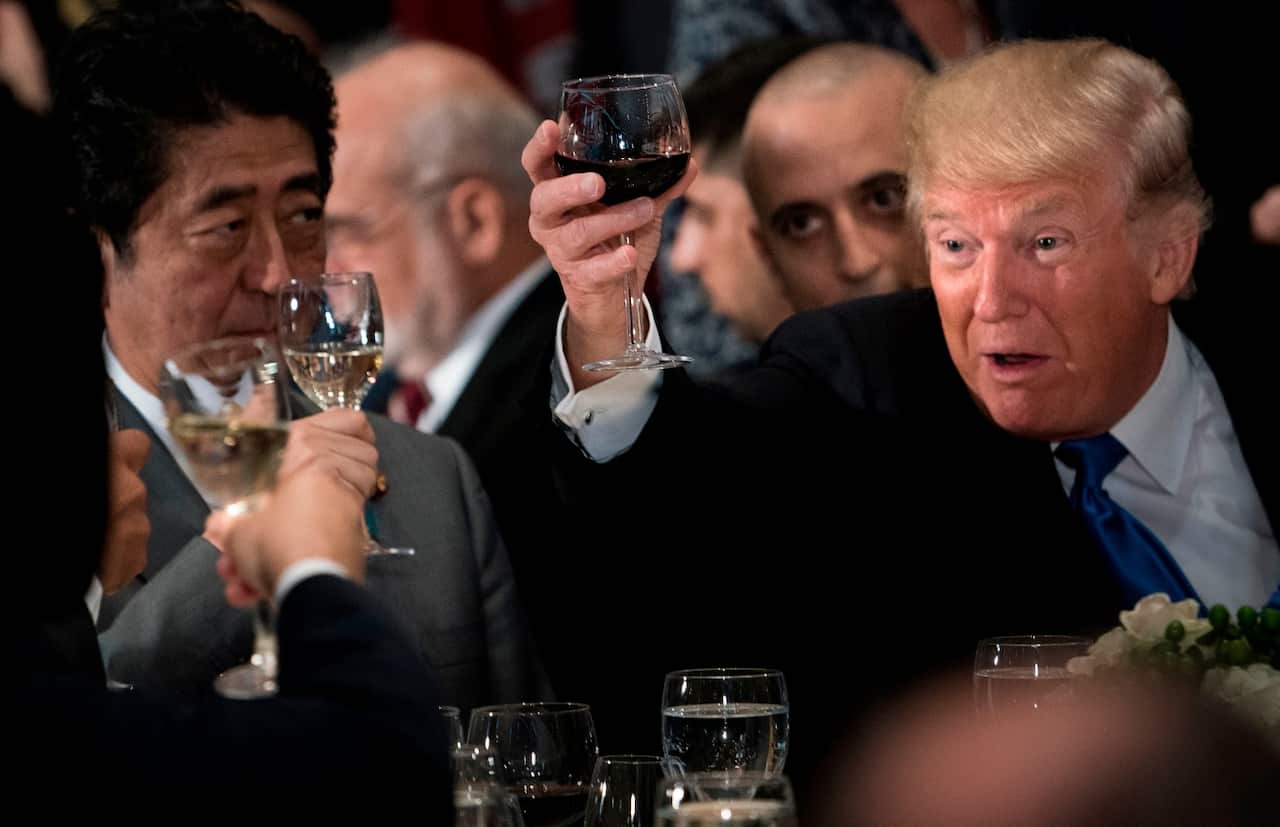 US President Donald Trump (R) raises his glass to a toast by UN Secretary-General Antonio Guterres, with Japan's Prime Minister Shinzo Abe (L) Sept 19, 2017