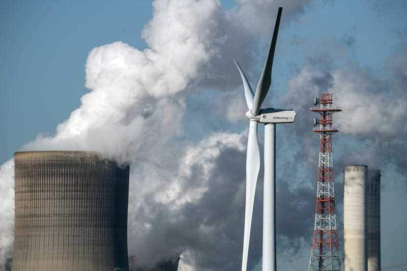 A wind turbine next to the  Niederaussem power plant in Germany. German authorities recommend a maximum wind turbine noise exposure of 55 decibels.
