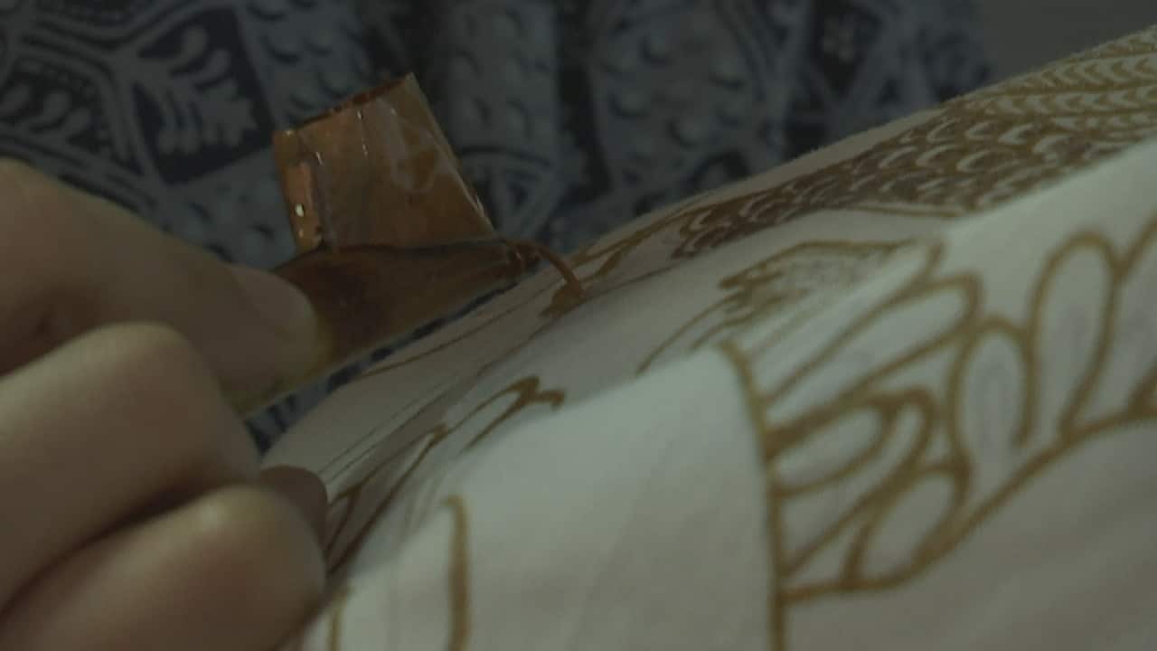 An Indonesian woman makes batik fabric.