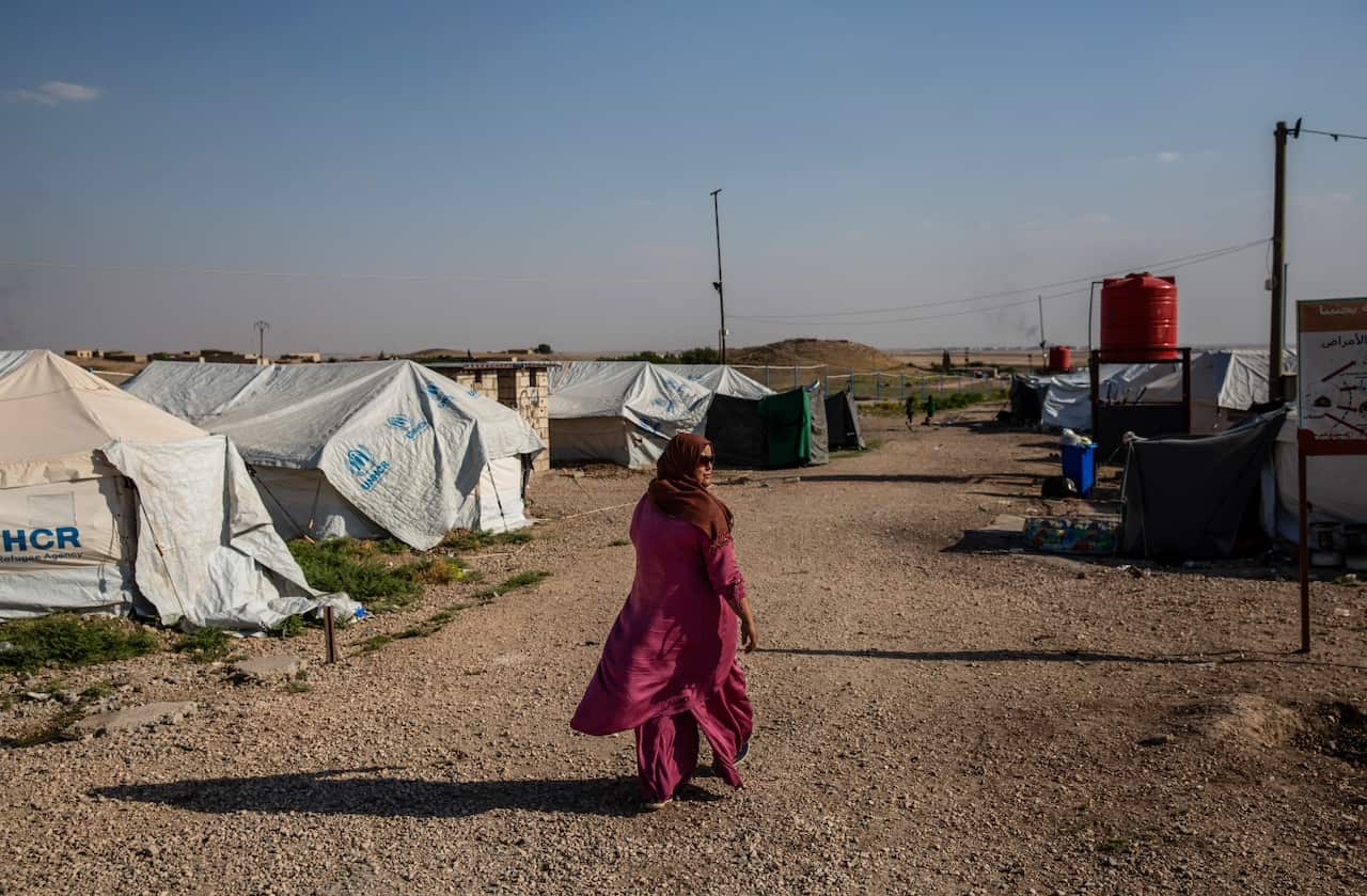 Sarah Ibrahim, 31, walks through a secure camp for the families of IS members, in Kurdish-controlled northern Syria, June 23, 2018.
