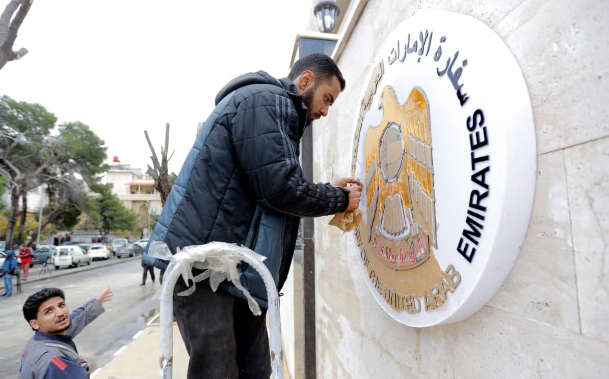 Workers clean the metal plaque on the outside wall of the United Arab Emirates embassy building (AAP)