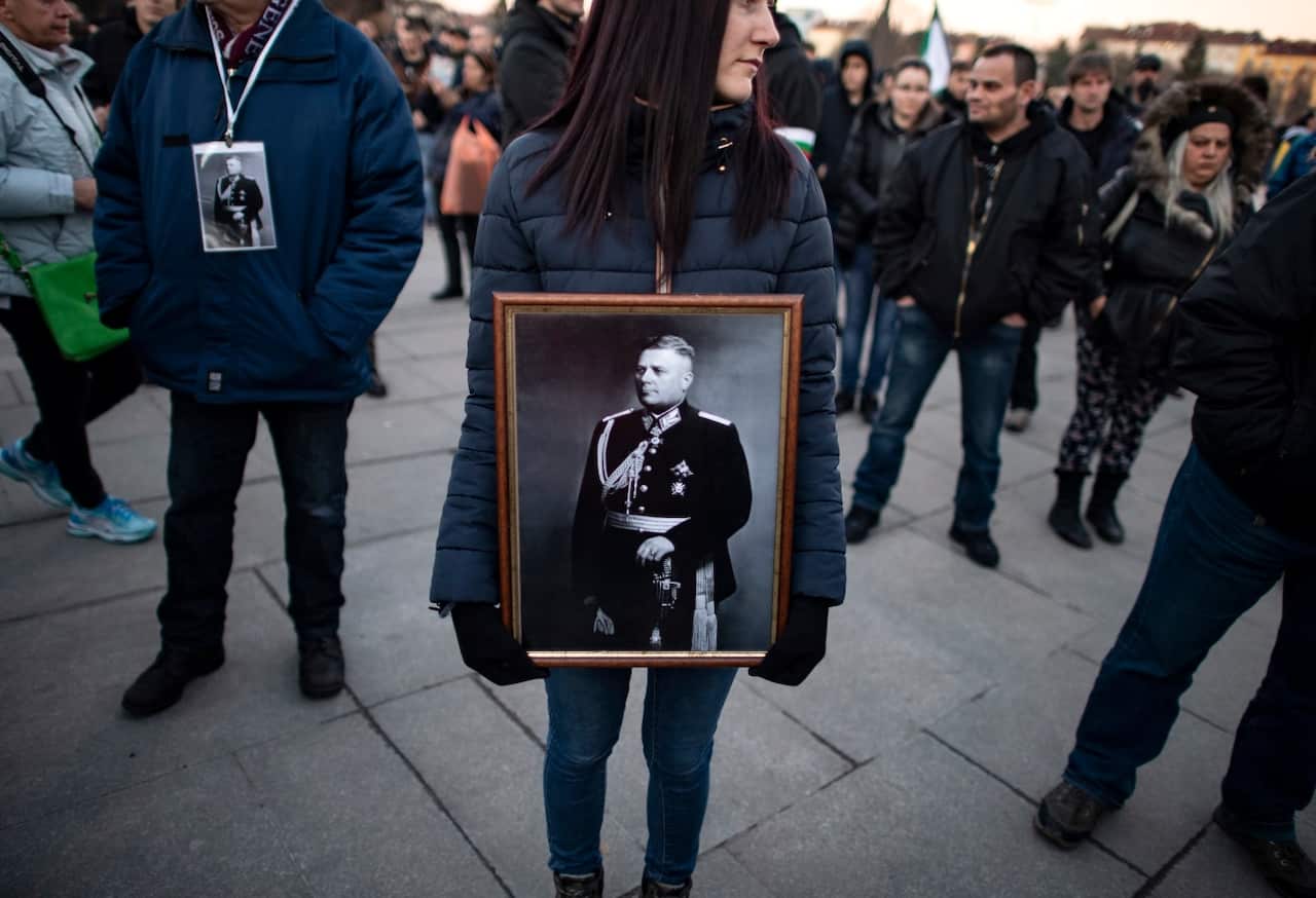 A woman holds a picture of General Hristo Nikolov Lukov.