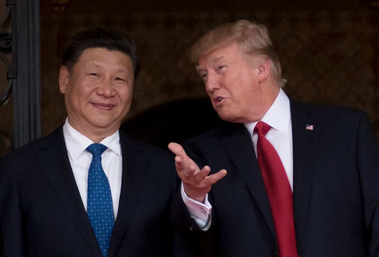 Chinese President Xi Jinping (R) waves to the press as he walks with US President Donald Trump at the Mar-a-Lago estate in West Palm Beach, Florida, April 7, 2017.