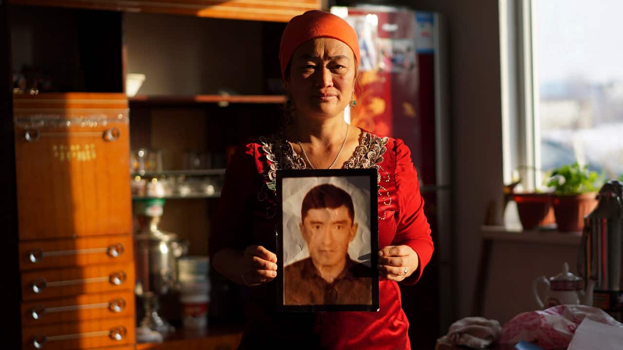 Mainur Medetbek holds up a portrait of her detained husband at her home in a village outside Almaty, Kazakhstan. 