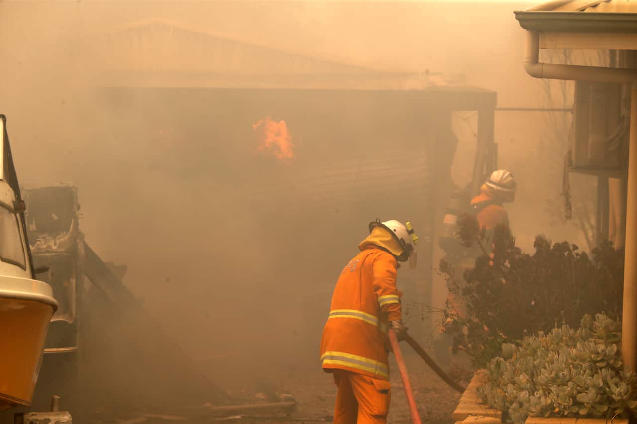CFS firefighters put out fires on Jacaranda Drive at Woodside in the Adelaide Hills.