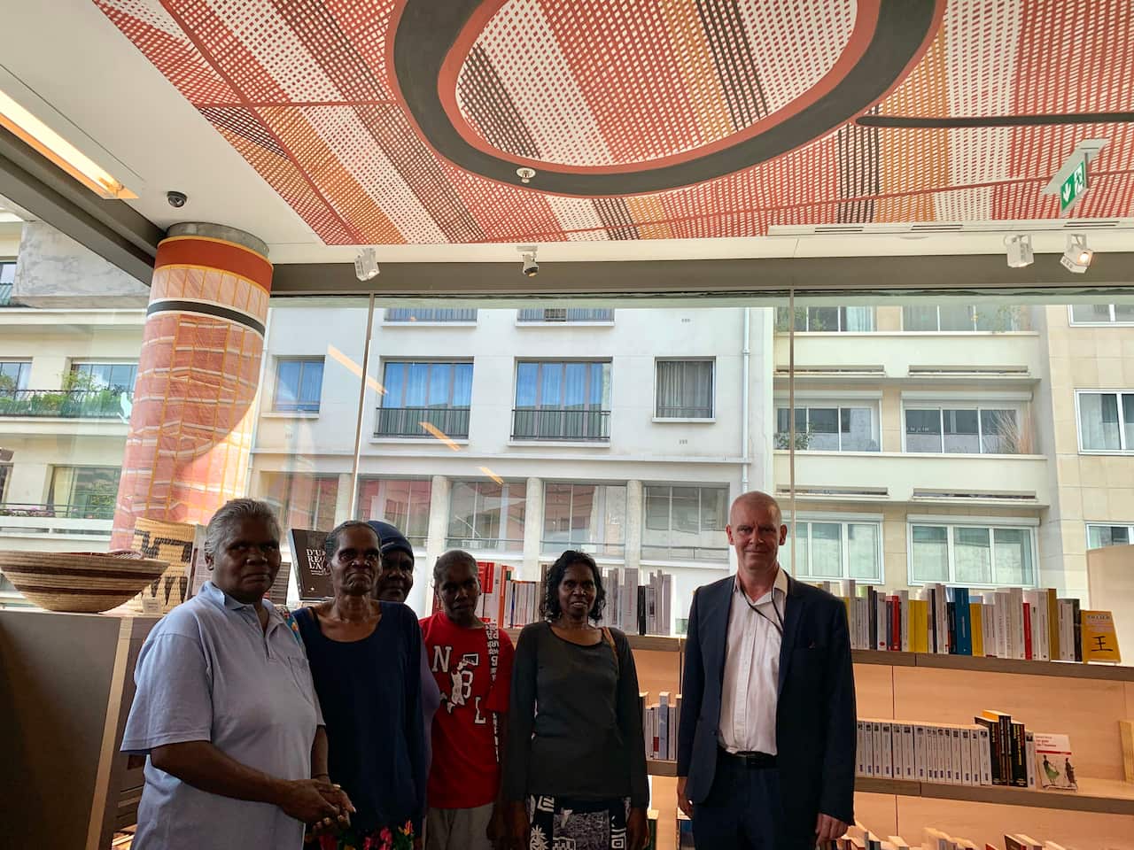 The Babbarra women stand below a ceiling painted by John Mawurndjul at the Musée du Quai Branly