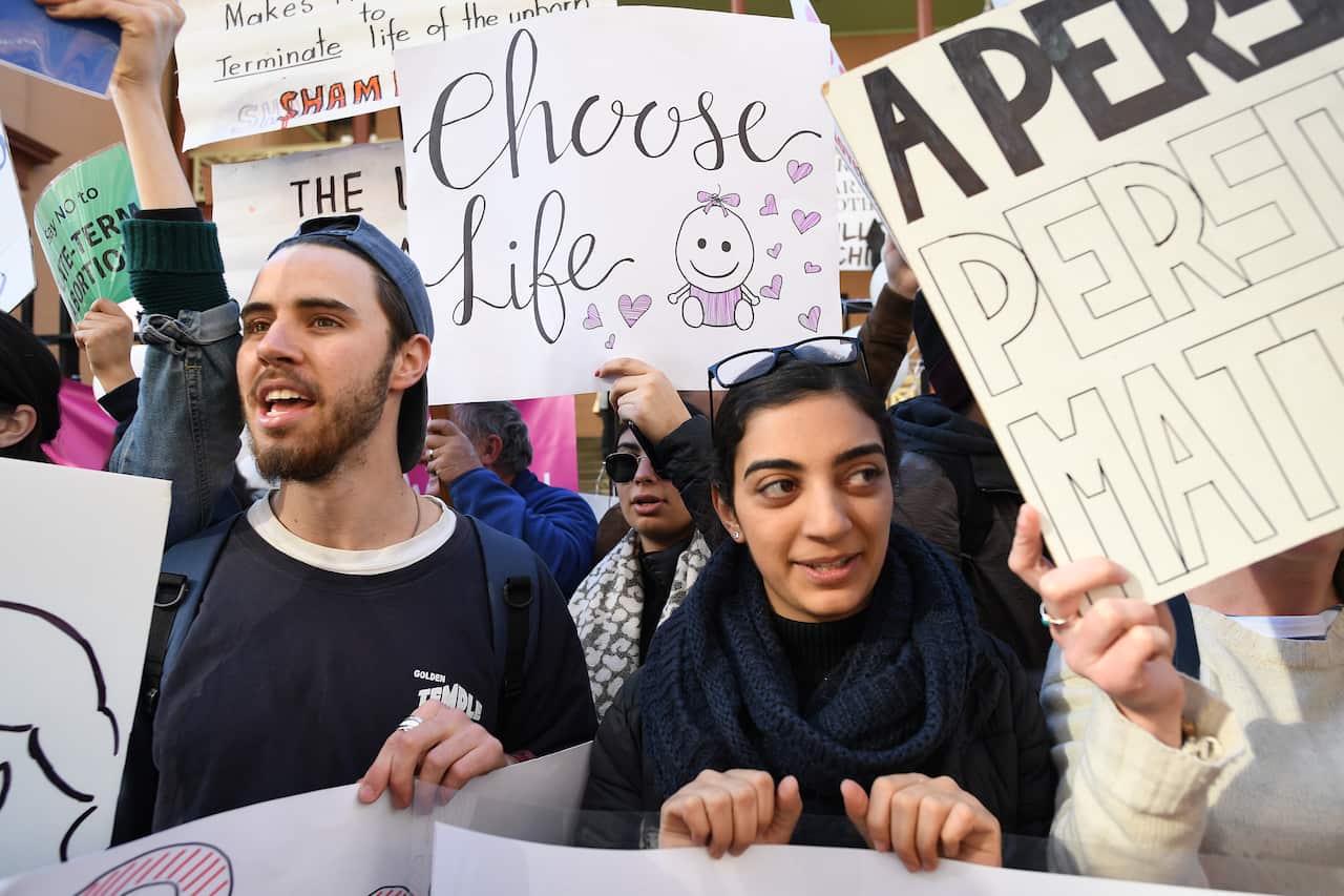 Pro-choice advocates hold placards during a rally outside the New South Wales Parliament.