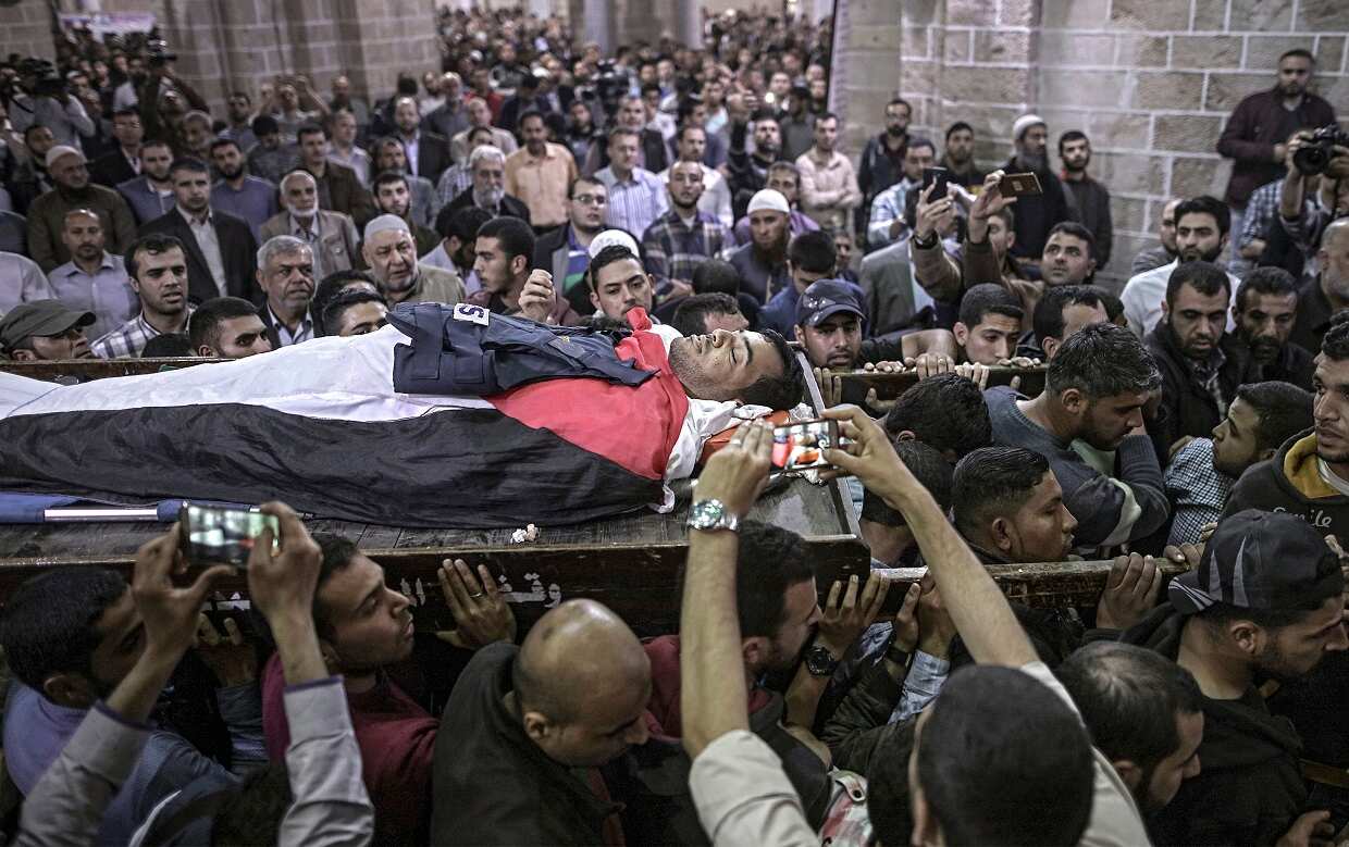 Palestinians mourners carry the body of cameraman Yasser Mourtaja, 30, during his funeral in Gaza City on April 7.