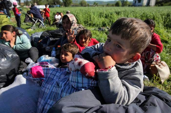 Yazidi migrant children wait to board buses on their way from the makeshift camp near village of Idomeni to another camp.