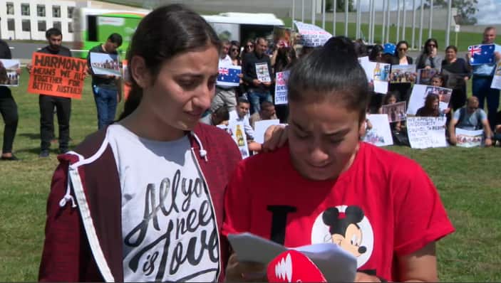 Yazidi teenagers Maryam Sloman (left) and Yvette Hasan (right) speaking outside Australia's Parliament House in Canberra.