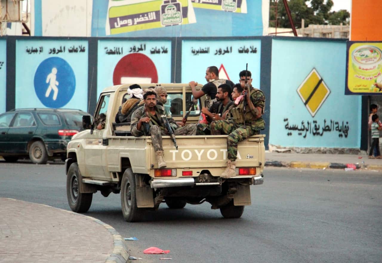 Armed supporters of the separatist Southern Movement patrol a street following clashes in the southern port city of Aden, Yemen, 28 January 2018 (AAP)