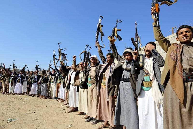Houthi rebel fighters brandish their weapons in Yemen. Fighting continues, despite a peace deal being hammered out by the various parties. 