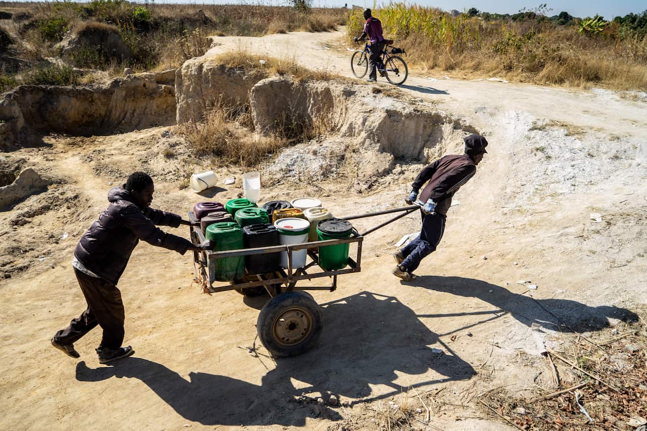Residents push a cart loaded with water containers filled from a spring outside Epworth, in Harare, Zimbabwe. (Zinyange Auntony/The New York Times)