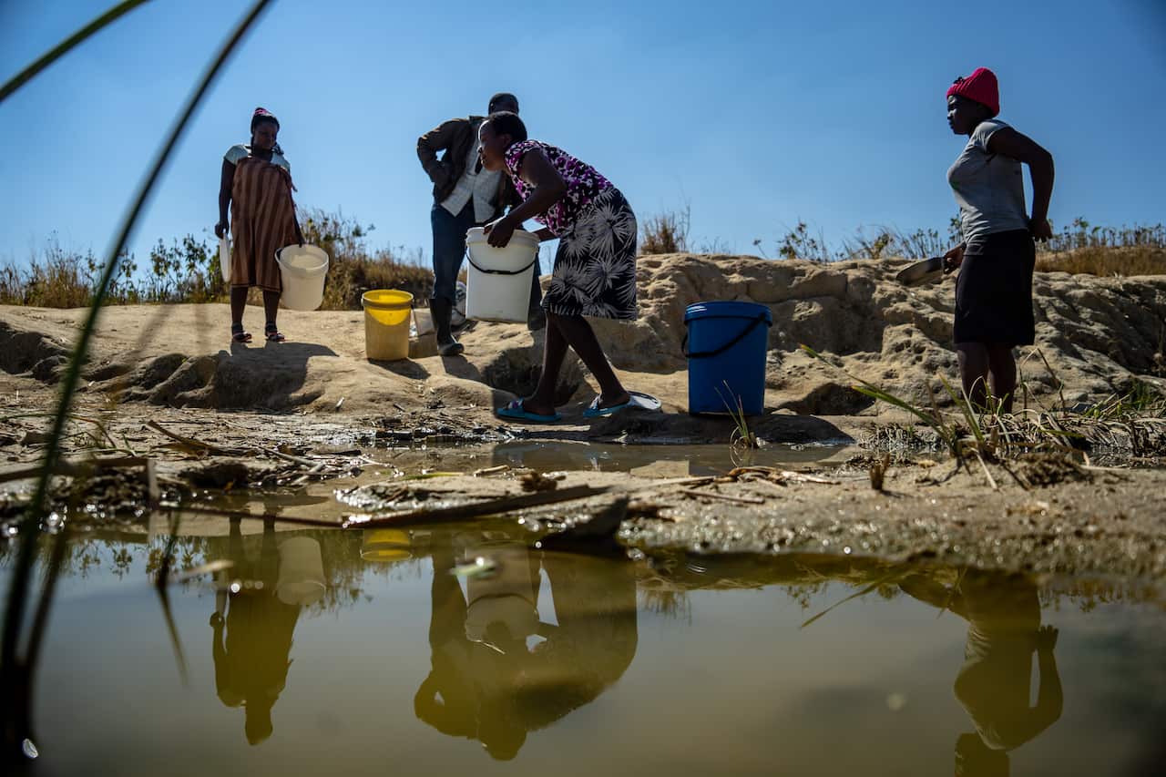 Residents collect water from a spring outside Epworth, in Harare, Zimbabwe. (Zinyange Auntony/The New York Times)