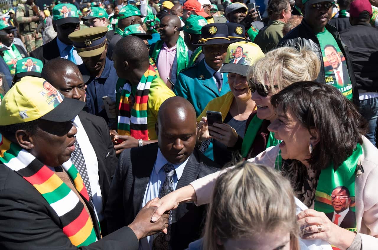 Zimbabwean President Emmerson Mnangagwa shakes hands after he addresses a meeting attended by farmers.
