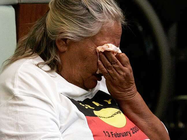 An Indigenous Australian woman cries in federal parliament as she listens to former prime minister Kevin Rudd deliver an apology to the Stolen Generations.