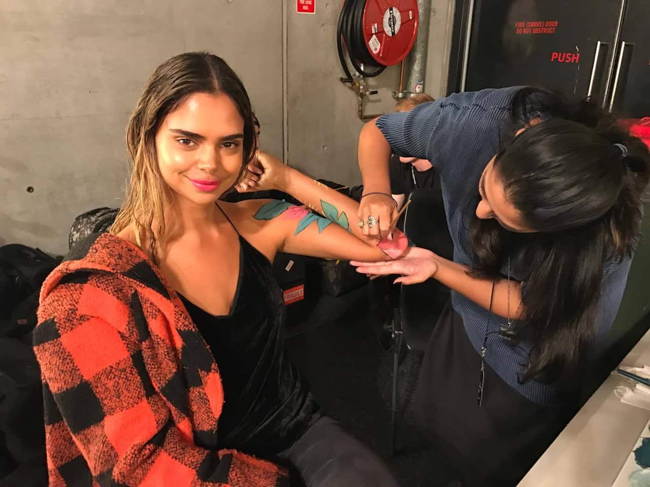 Sam Harris patiently having her arm painted for Fashion Week 2017