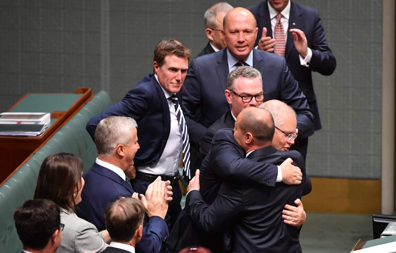 Prime Minister Scott Morrison hugs Treasurer Josh Frydenberg after handing down his first Federal Budget in the House of Representatives at Parliament House in Canberra, Tuesday, April 2, 2019. (AAP Image/Mick Tsikas) NO ARCHIVING