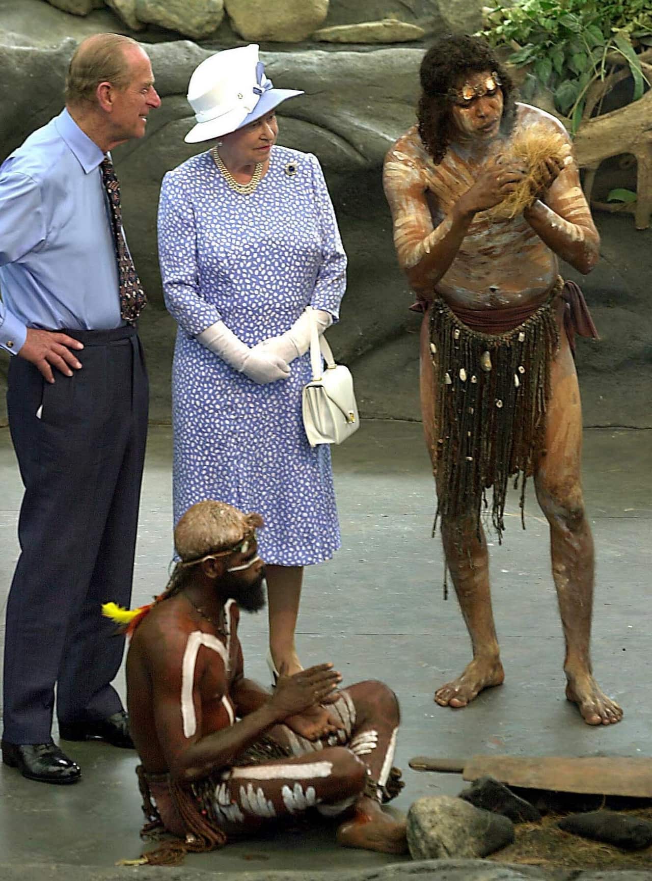 Britain's Queen Elizabeth II and Prince Philip watch as Warren Clements of the makes fire by rubbing sticks in Cairns, Australia, Friday, March 1, 2002.