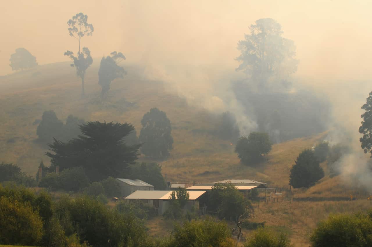 Bushfires smoke covers houses in Boolarra South in Gippsland, Victoria, Friday, Jan. 30, 2009. Up to 11 homes have been destroyed with others damaged as firefighters battled large fires raging across Victoria. (AAP Image/Joe Sabljak) NO ARCHIVING