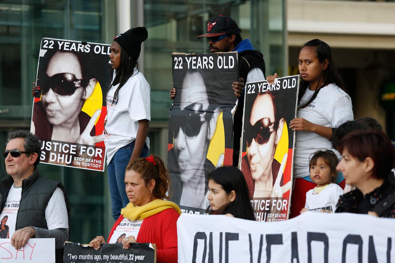 Protesters hold signs as around 100 people rallied in Perth's CBD on August 4, 2015 to mark the first anniversary of the death of Miss Dhu.