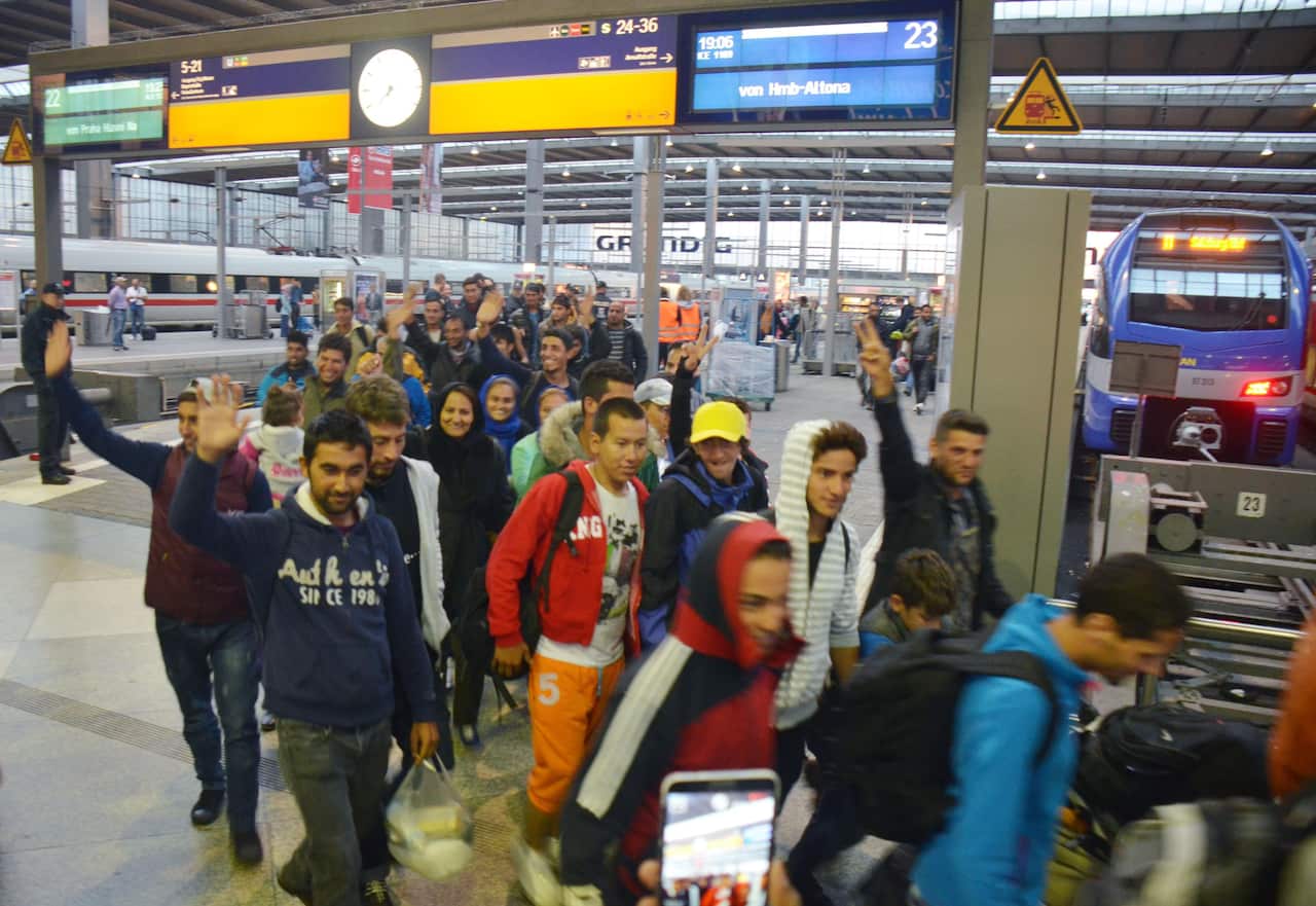 Smiling refugees arrive at the central train station in Munich 