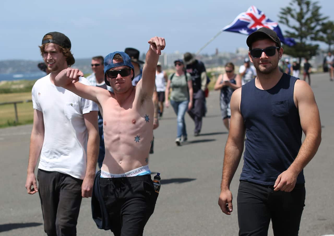 Men gesture as they arrive to attend a rally commemorating 10 years since the Cronulla riots at the Don Lucas reserve in Cronulla, Sydney, Saturday, Dec. 12, 2015. (AAP Image/David Moir) NO ARCHIVING