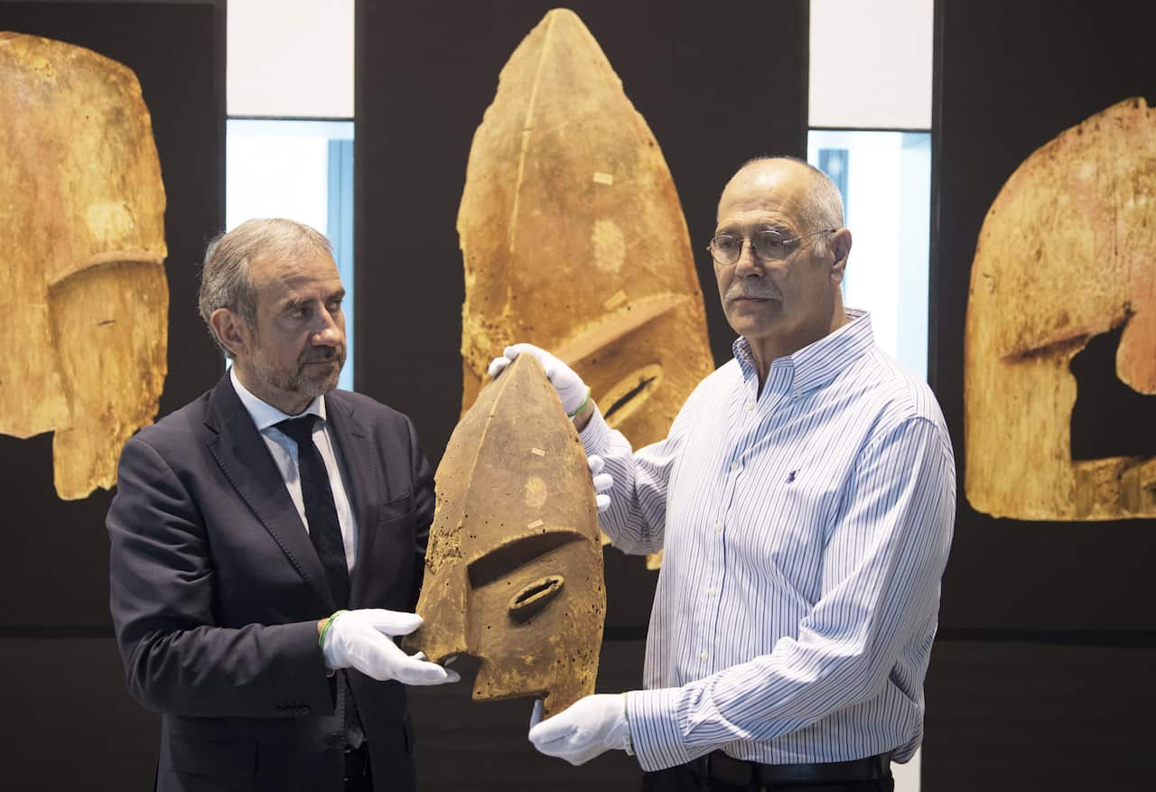 John Johnson, right, of the Chugach Alaska Corporation and Hermann Parzinger, left, President of the Prussian Cultural Heritage Foundation, show a historical wooden item, plundered from the graves of indigenous Alaskans