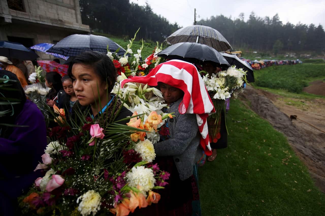 A procession of mourners fill the road