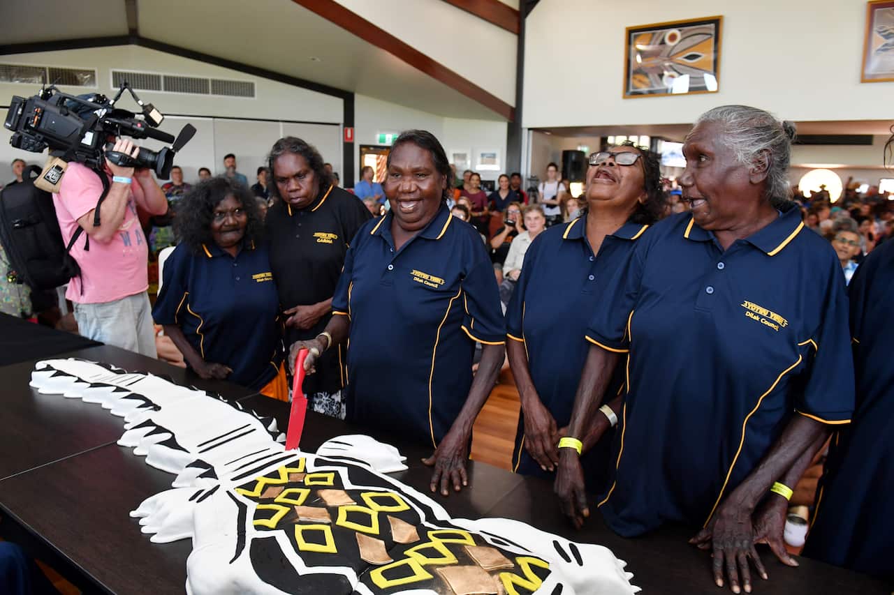 Local Yolngu women elders celebrate as they cut a cake to commemorate the 20th anniversary of the Garma Festival. (AAP Image/Mick Tsikas)