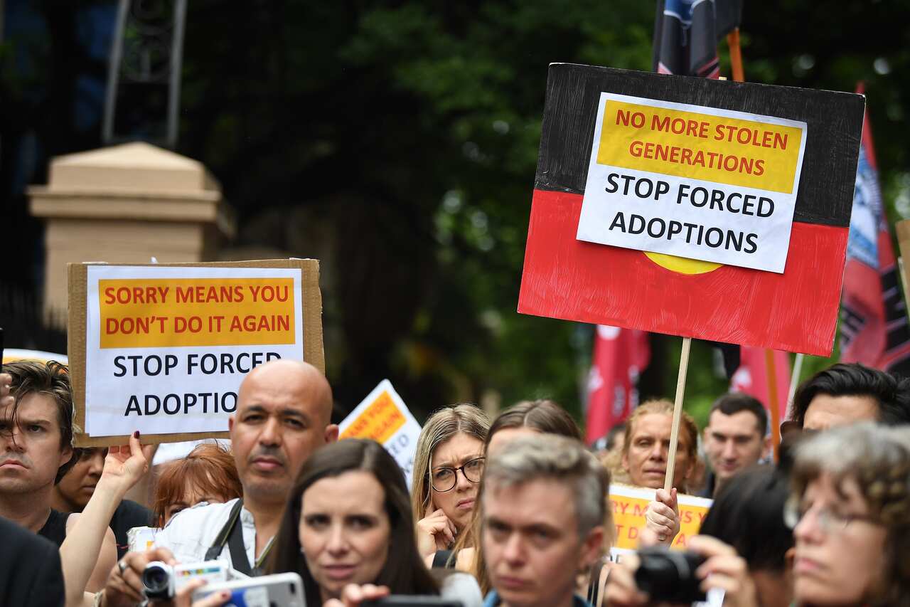 Protesters hold placards at the Stop Forced Adoptions: Reject the Child Protection Bill Protest outside Parliament House in Sydney, Wednesday, November 14, 2018. (AAP Image/Joel Carrett) NO ARCHIVING