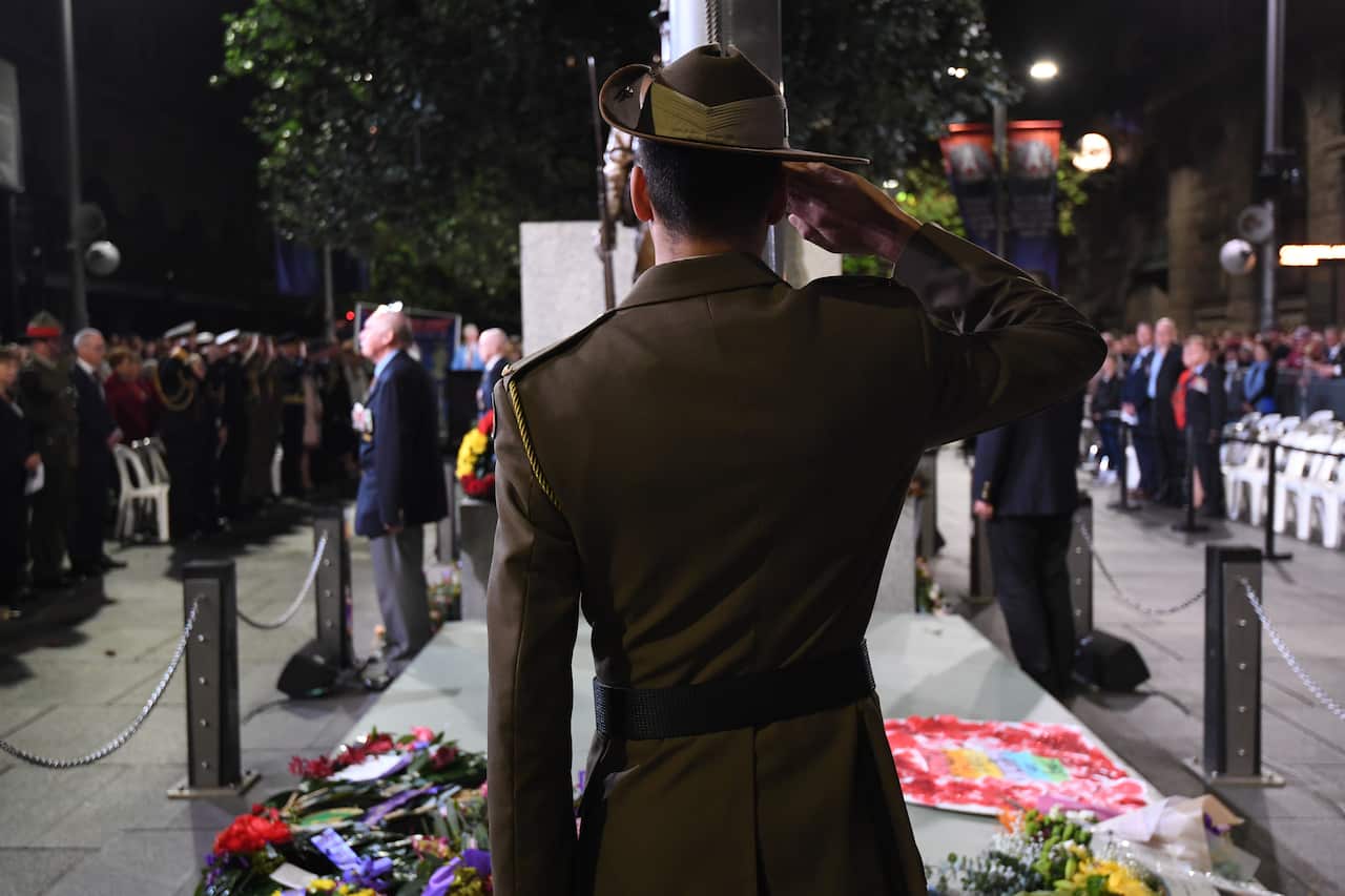 A flag bearer salutes during the Anzac Day Dawn Service at The Cenotaph in Sydney, Thursday, April 25, 2019. (AAP Image/Dean Lewins) NO ARCHIVING