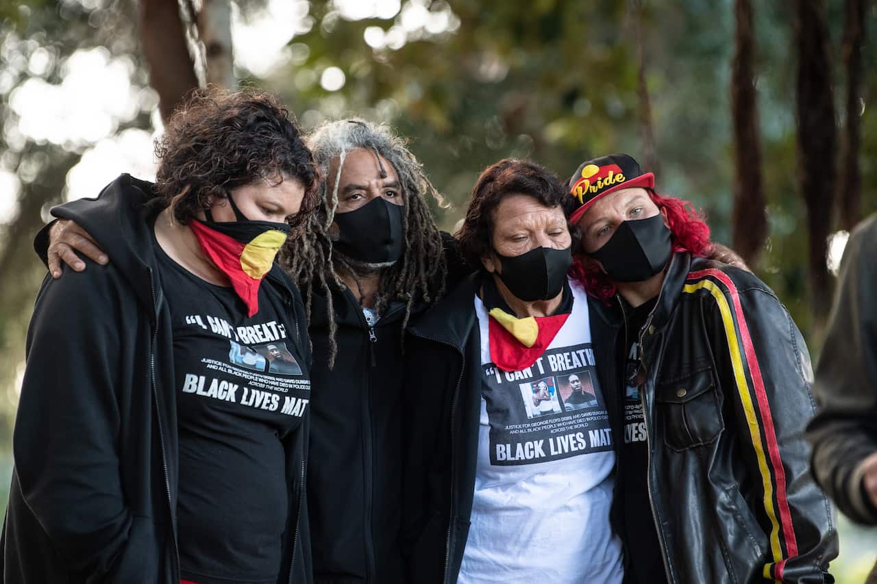 Leetona Dungay (second right), and Elizabeth Jarrett (right) embrace with supporters during a press conference in Sydney.