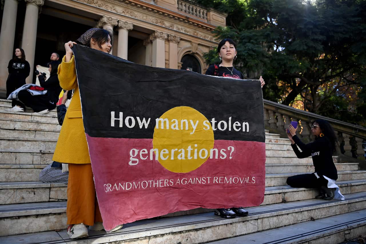 Protesters hold placards during a Stop The Stolen Generation! Sorry Day Rally in Sydney