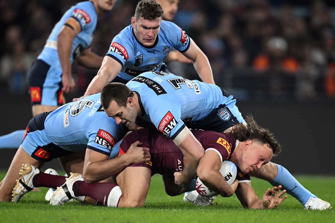 Reuben Cotter of the Maroons is tackled