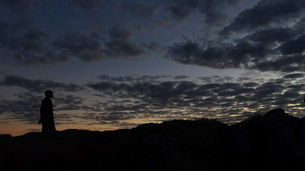 Local indigenous rangers wait for sunset at Ubirr rock in the World Heritage listed Kakadu National Park, Darwin, Thursday, July 2, 2015. (AAP Image/Dean Lewins) NO ARCHIVING