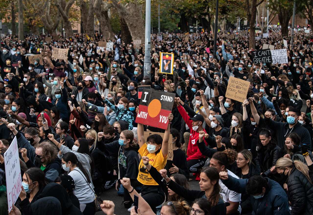 Thousands of protesters kneel and salute at a Black Lives Matter rally in Sydney