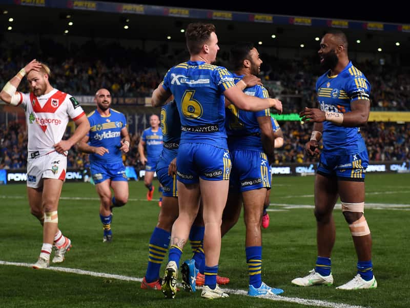 Bevan French (centre) of the Eels is congratulated after scoring a try