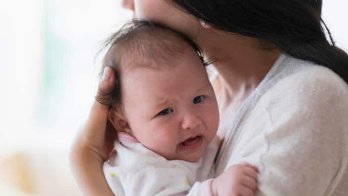 Asian mother comforting crying baby