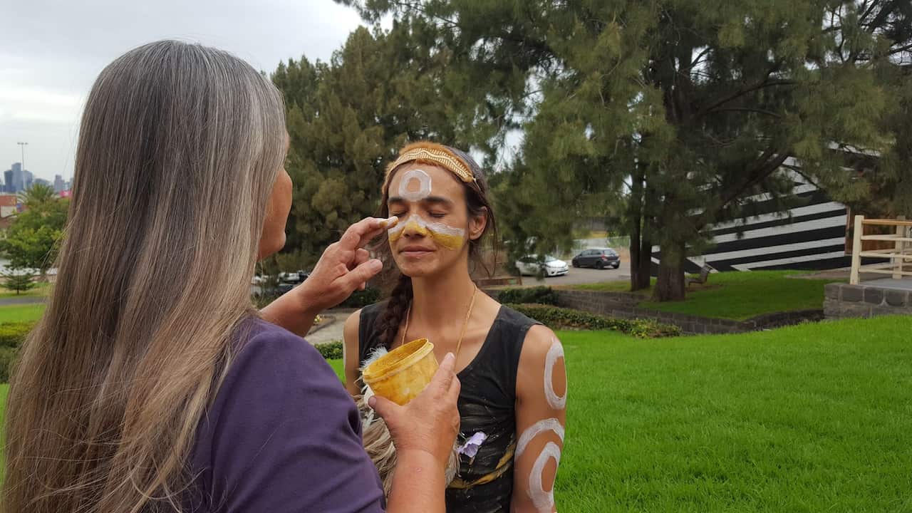 Aunty Vicki applying ochre to Yaraan's face
