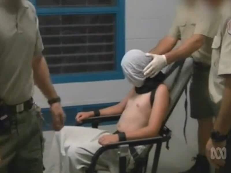 Former inmate Dylan Voller is seen restrained in a spithood