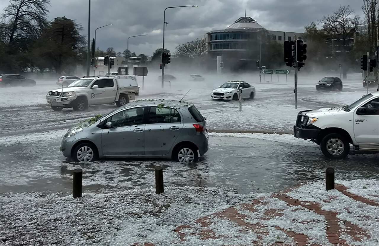 Hail covers vehicles in an intersection in Canberra.