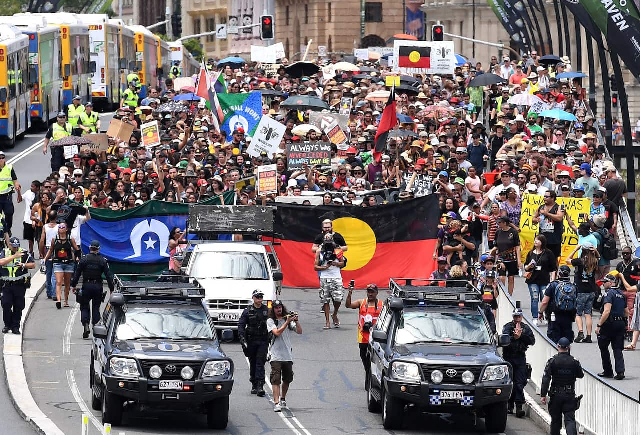 Indigenous protesters march through central Brisbane to protest what the call "Invasion Day" on Australia Day in Brisbane, Thursday, Jan. 26, 2017 (AAP)