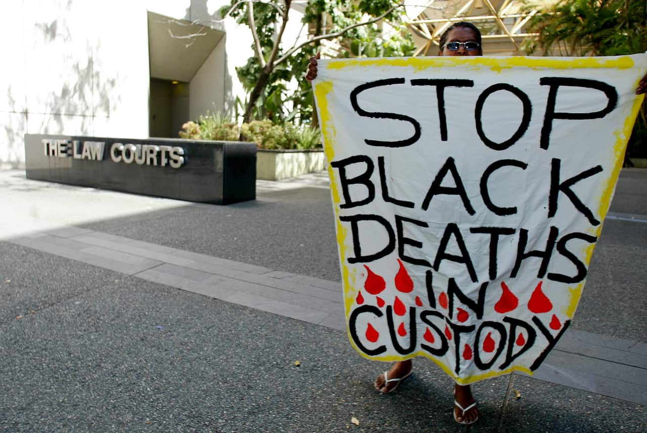 A Lex Wotton suppoter wave a banner during this morning court hearing in Brisbane, Monday, Oct. 6, 2008. Mr Wotton is charged with alledgedly inciting the November 2004 riots on Palm Island in northern Queensland. (AAP)