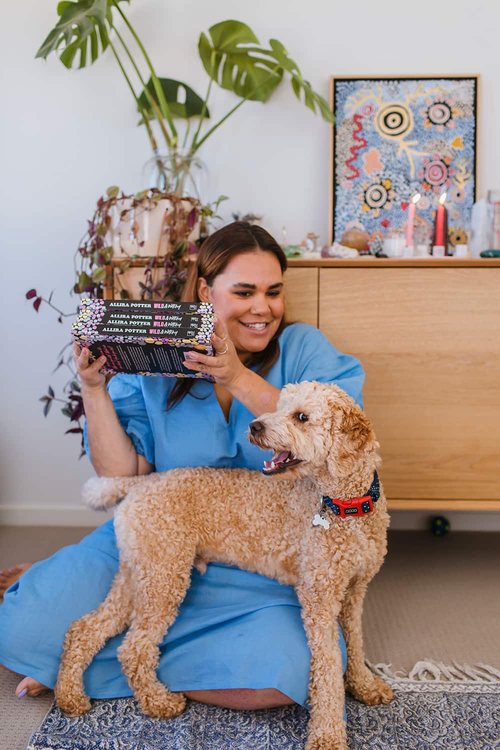 Allira Potter with dog Cosmo holding debut book, Wild & Witchy