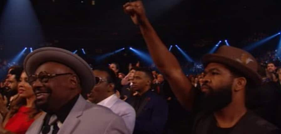 An audience member gives Kendrick Lamar's performance the black salute